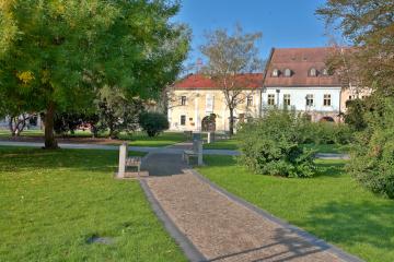 Pohľad na budovu múzea cez park na námestí Pohľad na budovu múzea cez park na námestí